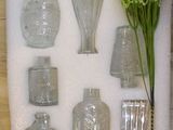 bottles and vases are arranged in a display case on a table