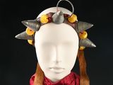 a white mannequin headpiece with metal spikes on it