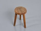 stool made of wood with a wooden seat on a gray surface