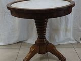 a small table with a marble top on a tile floor