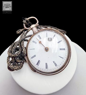 a white plate with a gold pocket watch on it