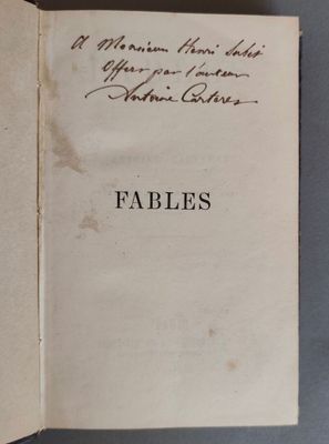 un livre ouvert avec une écriture dessus, posé sur une table