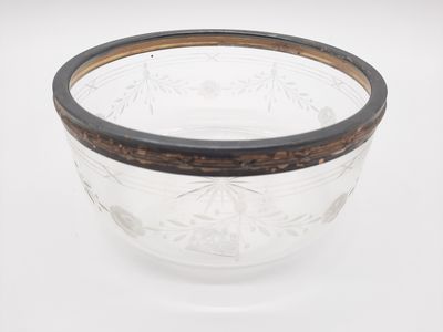 un bol en verre dont le bord est marron sur un fond blanc