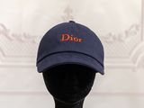 blue baseball cap with orange dior embroidered on the front