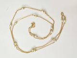 necklace with pearls and gold chain on white background