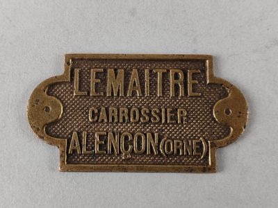 a close up of a metal sign on a white surface