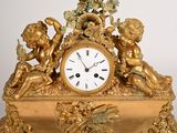a gold clock with cherensils on top of it