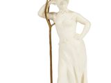statue d'une femme tenant une faux, debout sur un socle