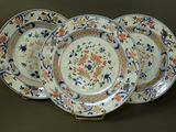 trois assiettes ornées de motifs floraux sont posées sur une table
