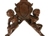 une image représentant une horloge en bois sur laquelle figurent deux chérubins