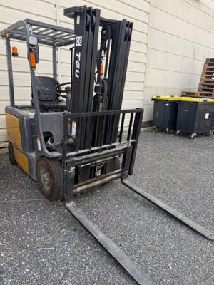 a fork lift truck that is parked in front of a building
