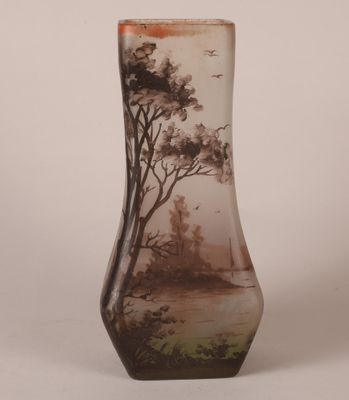 un vase en verre orné d'une peinture représentant des arbres