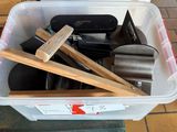 un bac en plastique rempli d'outils posé sur un sol carrelé