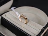 une bague en or dans un écrin noir orné d'un ruban blanc