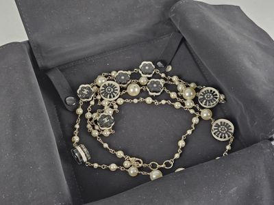 bracelet présenté dans un coffret noir, orné de perles et de breloques