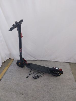 un scooter posé par terre devant un mur