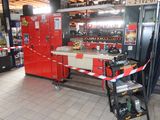 une photo d'un magasin avec un réfrigérateur rouge et un établi