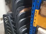 a lot of chairs that are stacked up in a warehouse