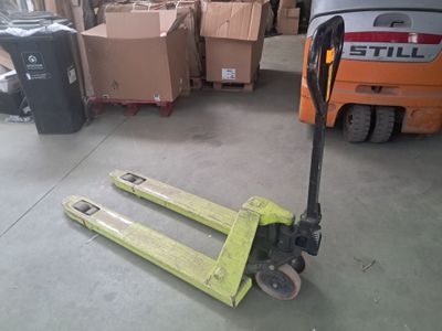 un chariot élévateur avec des cartons posés au sol dans un entrepôt
