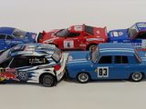 several toy cars are lined up in a row on a white surface