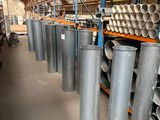 rows of metal pipes are lined up in a warehouse