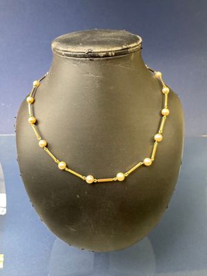 une vitrine sur laquelle sont exposés un collier et des boucles d'oreilles