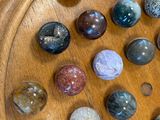 a lot of marbles that are on a wooden plate