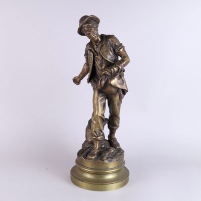 une vieille statue en bronze représentant un homme avec un chien, posée sur un socle