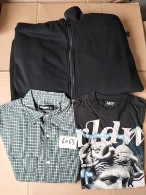 three men ' s shirts in a box with a tag on them