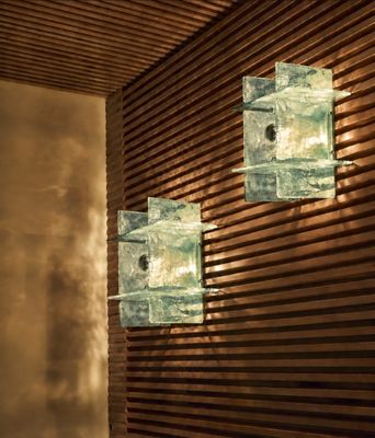 Trois cubes de verre sont fixés sur un mur en bois dans une pièce