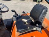 a tractor that has a seat on it in the parking lot