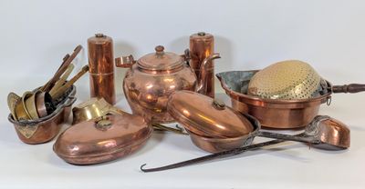un grand nombre de casseroles et de poêles en cuivre posées sur une table