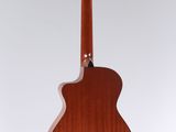 an acoustic guitar hanging from a string on a wall