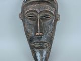 une image d'un masque en bois sur fond blanc