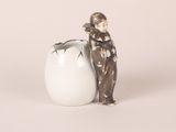 a figurine of a man standing next to an egg