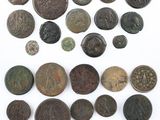 an assortment of ancient coins on a white surface