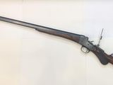 a rifle with a wooden barrel on display in a glass case