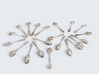several silver spoons arranged in a circle on a white surface