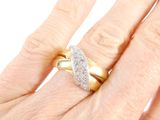 a woman ' s hand holding a gold and diamond ring