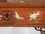 a small wooden table with a bird design on it