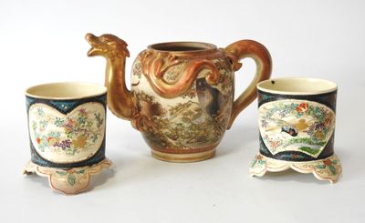 three cups and a teapot sitting next to each other