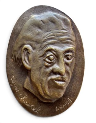 un gros plan d'une plaque en bronze sur laquelle figure le visage d'un homme