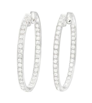 une paire de boucles d'oreilles en diamant sur fond blanc