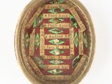 une photo d'une broche rouge et dorée sur laquelle figurent des mots