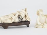paire de figurines en ivoire sculpté représentant un homme et une femme allongés sur un lit