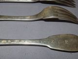 three forks that are sitting next to each other on a table