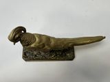 brass pheasant figurine on stand on white background