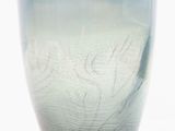 a glass vase with a pattern on it on a white surface