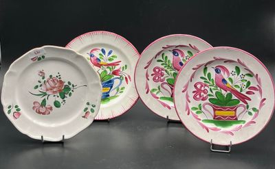 three plates with pink and green designs on them on a black surface