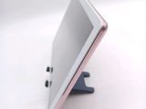 a tablet computer sitting on a stand on a white surface